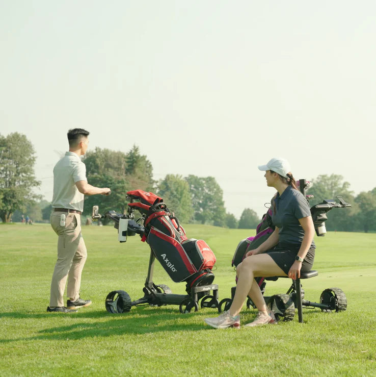 Lifestyle image of two golfers using golf trundlers. One standing and one sitting